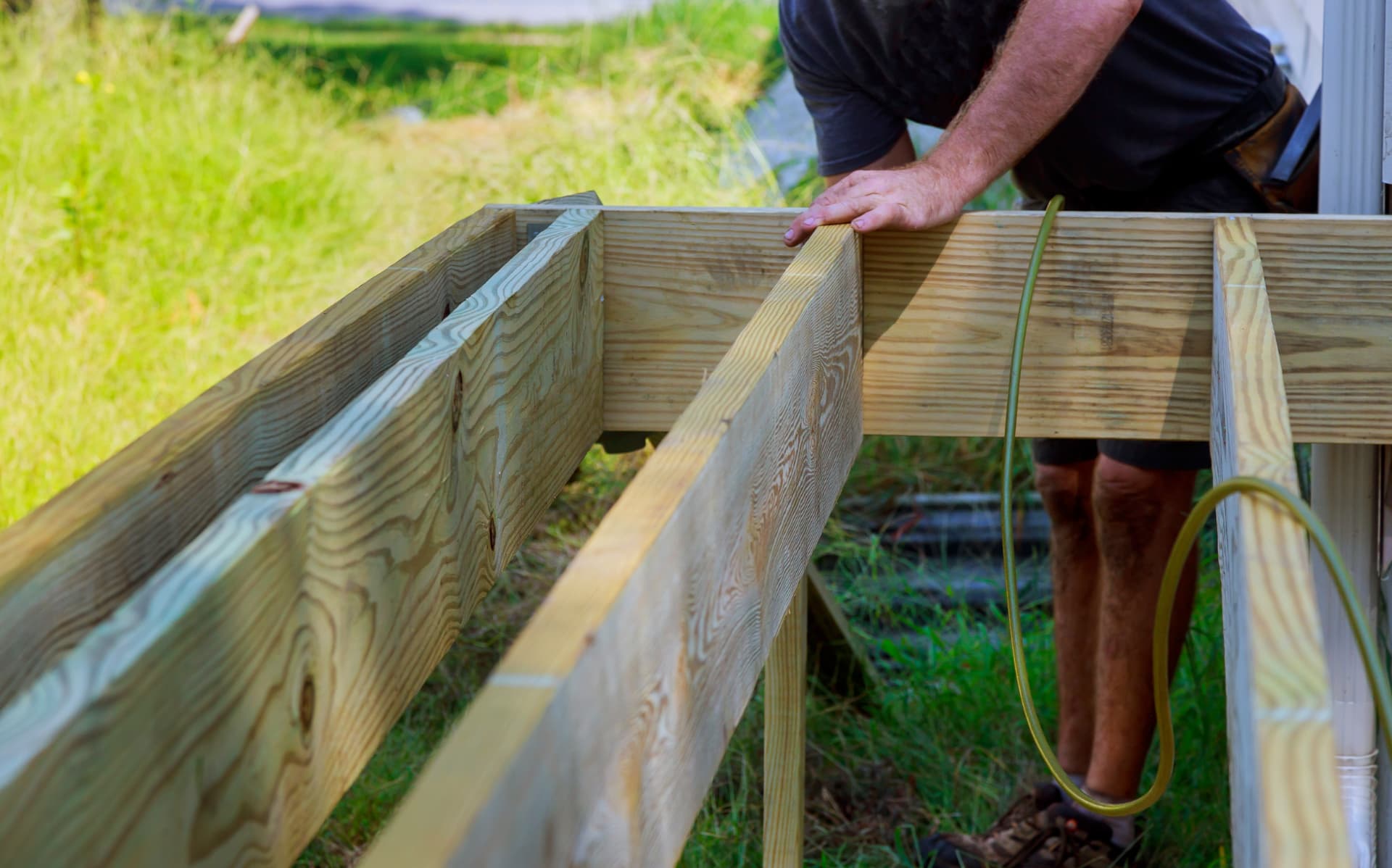 Decking by SOS Landscaping: Pressure-treated timber decking frame with joists set level before boarding
