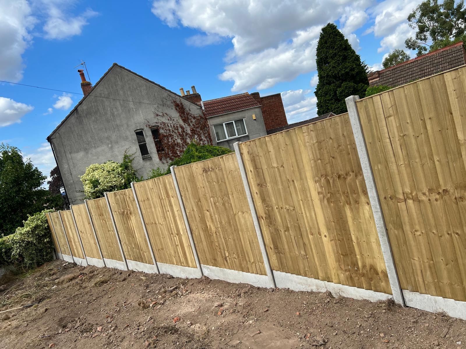Fencing by SOS Landscaping: New close-board timber fence with concrete posts and gravel boards running on a level line