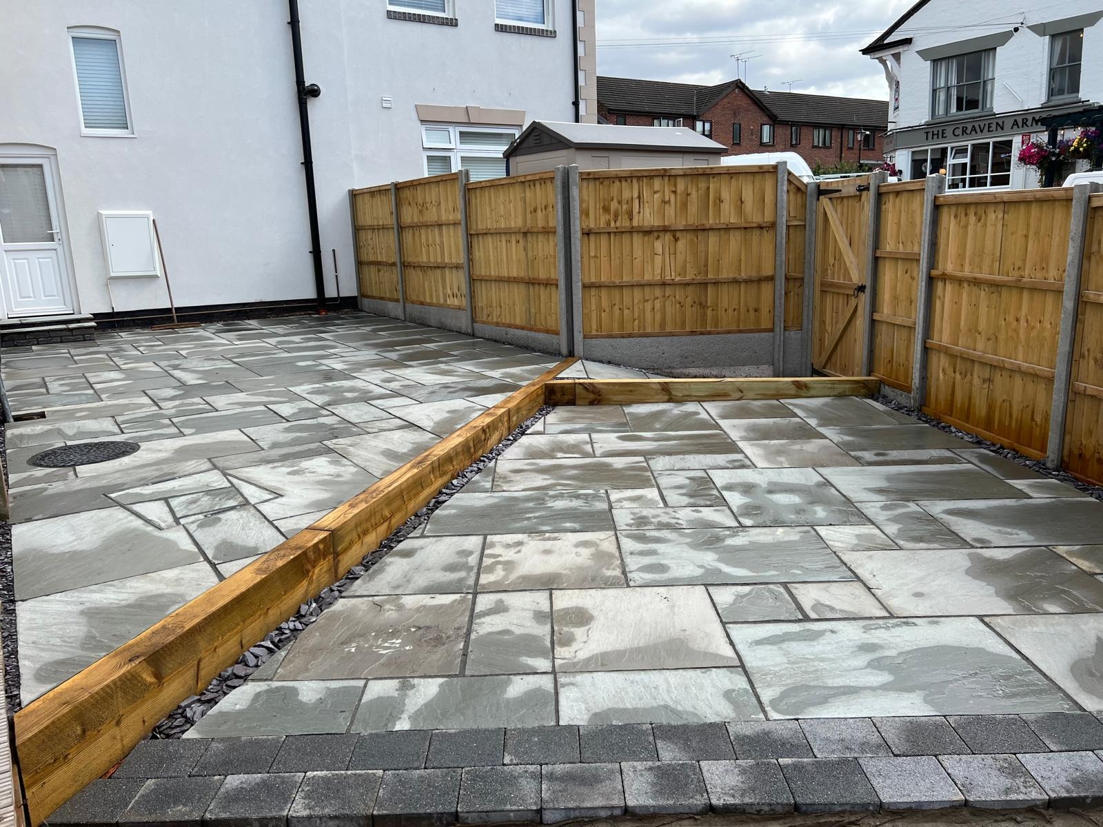 Sleeper walls & steps by SOS Landscaping: Two-level sandstone patio divided by sleeper edging with slate infill and new fencing